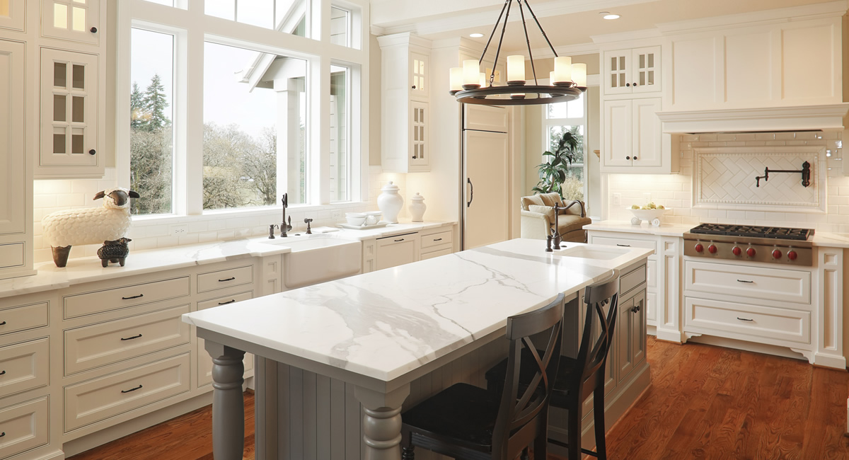 Bright kitchen with a marble island and professional range